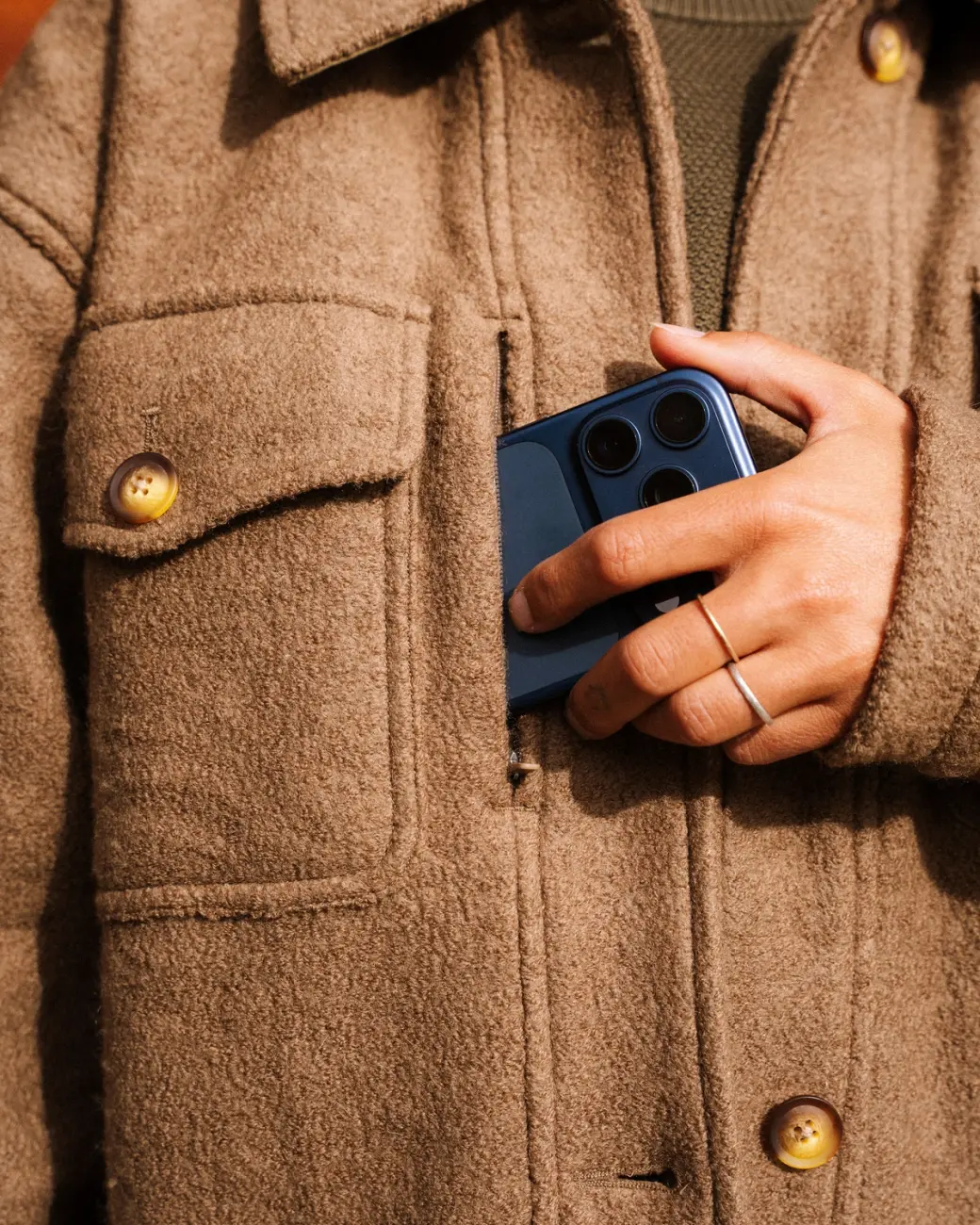 An image of someone putting a phone into a zippered pocket