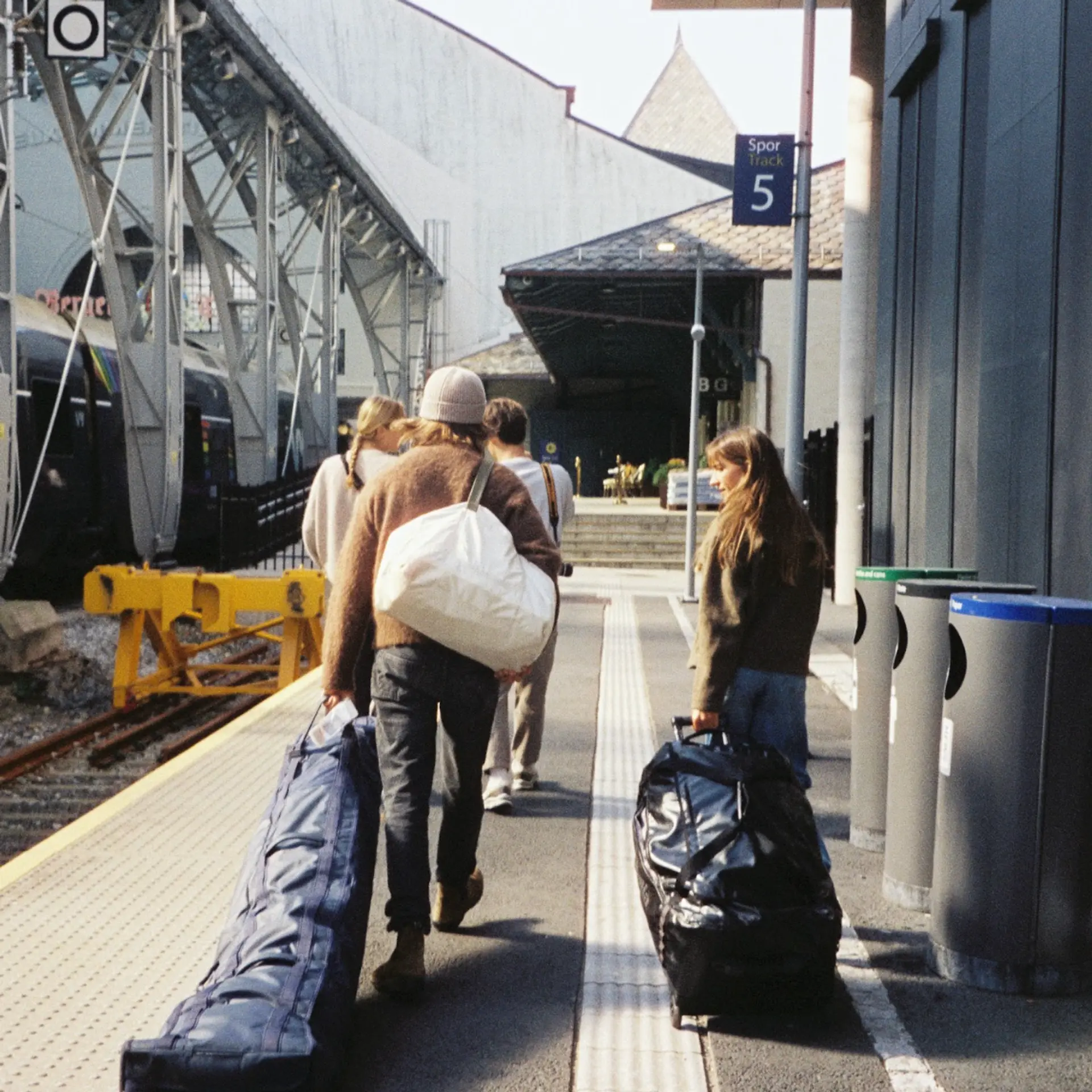 An image of people traveling with ski bags