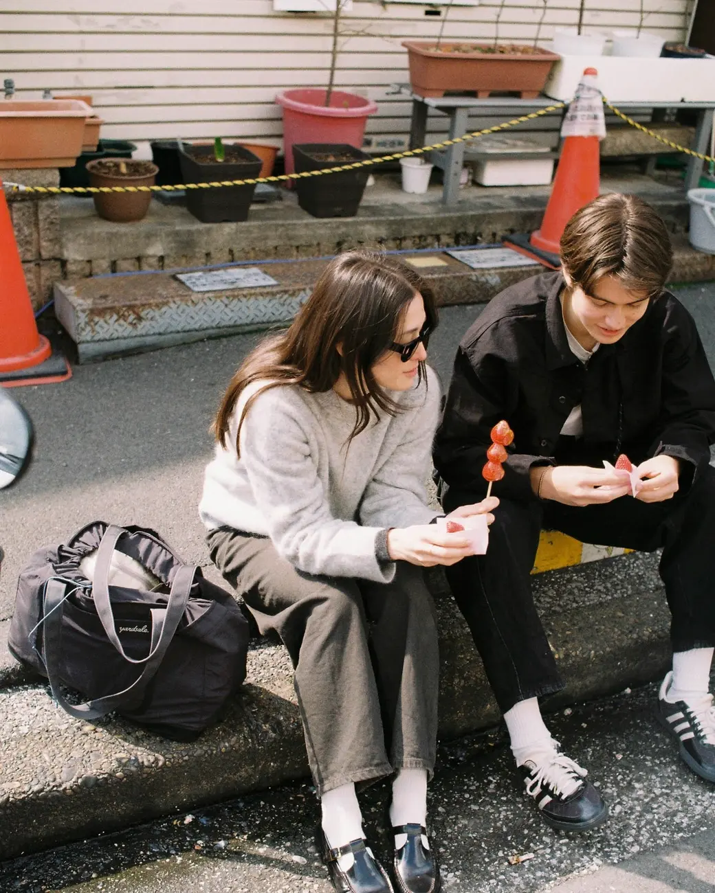 An image of two people on a curb with a 20L Day Bag 