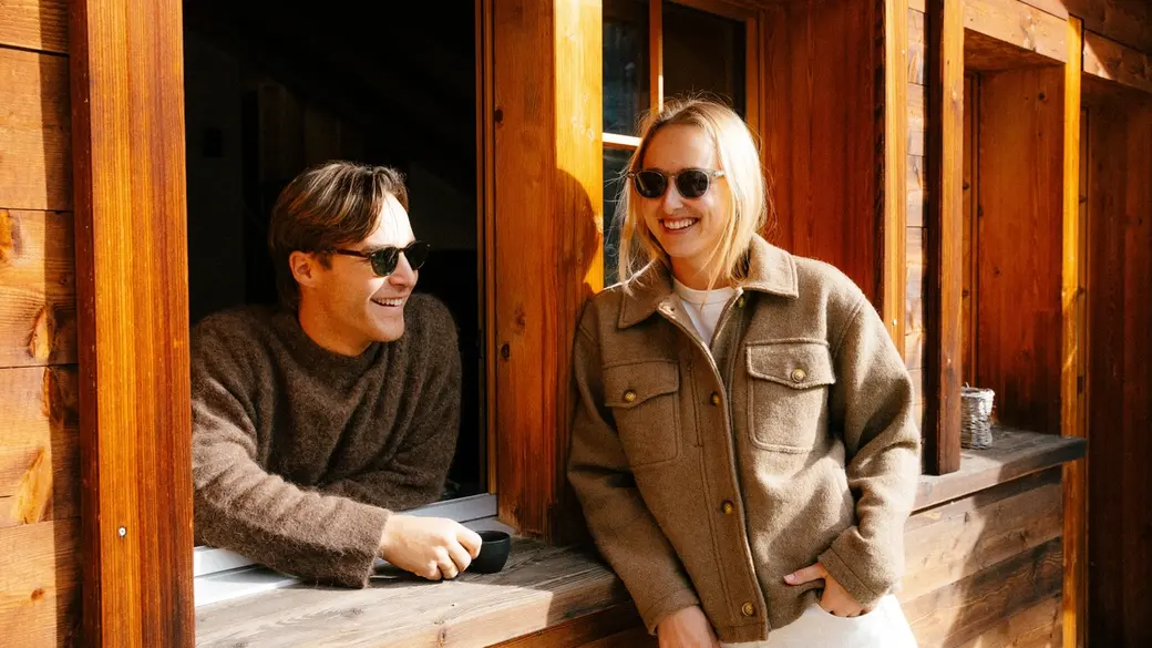 An image of two people outside of a cabin
