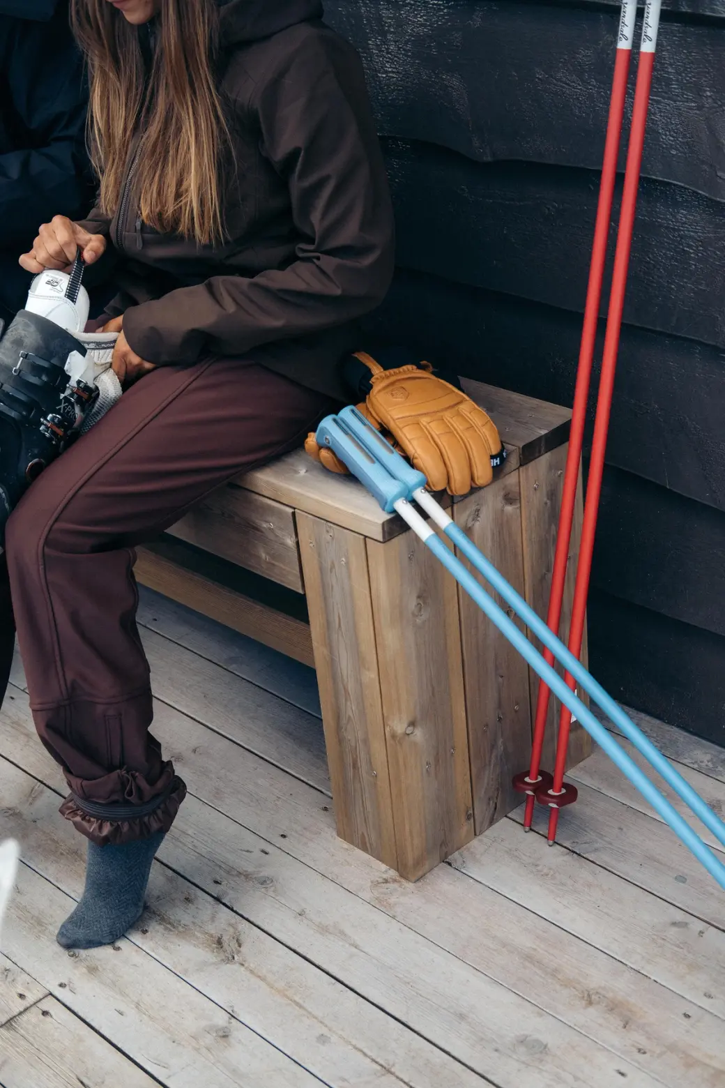 An image of ski poles resting on the side of a cabin
