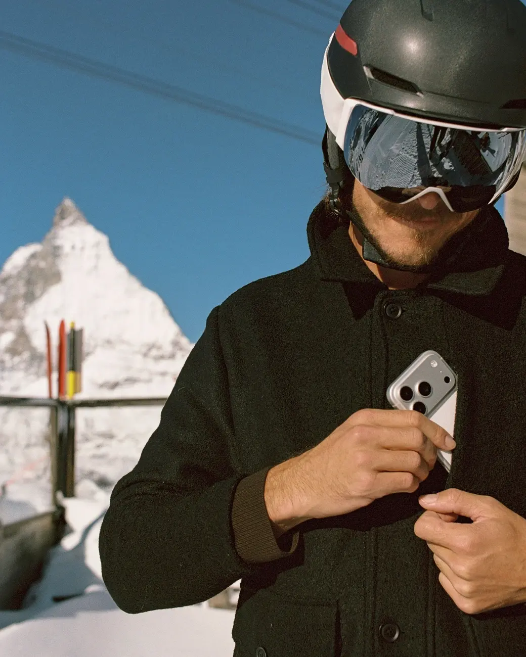 An image of someone putting a phone into a zippered pocket