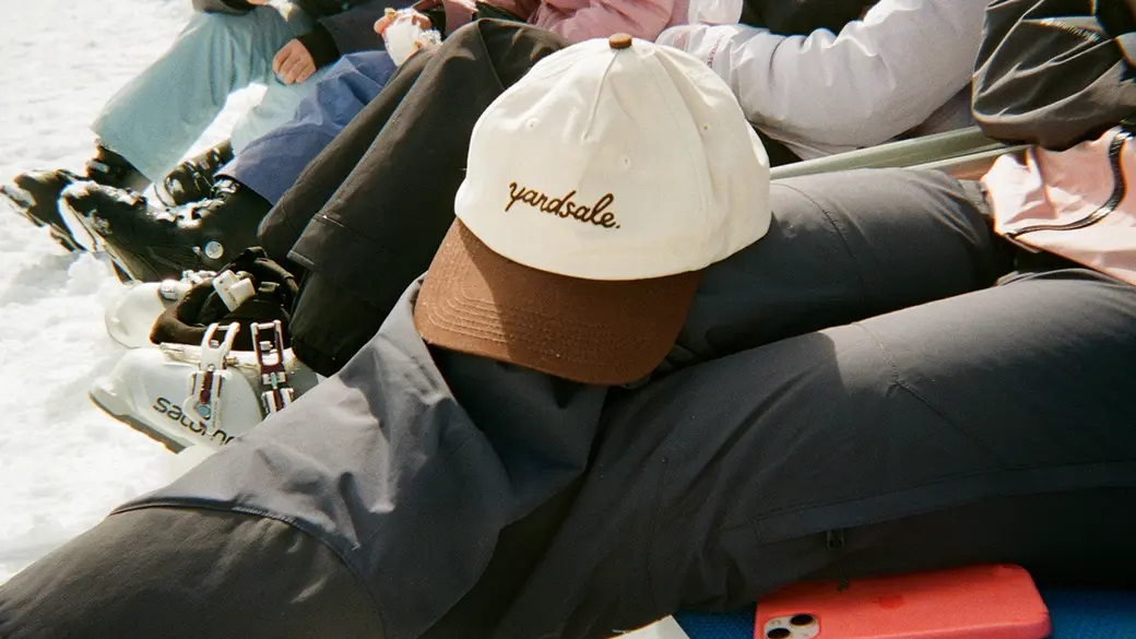 An Image of a hat resting on a person's legs