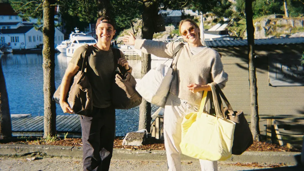 Two people smiling with day bags