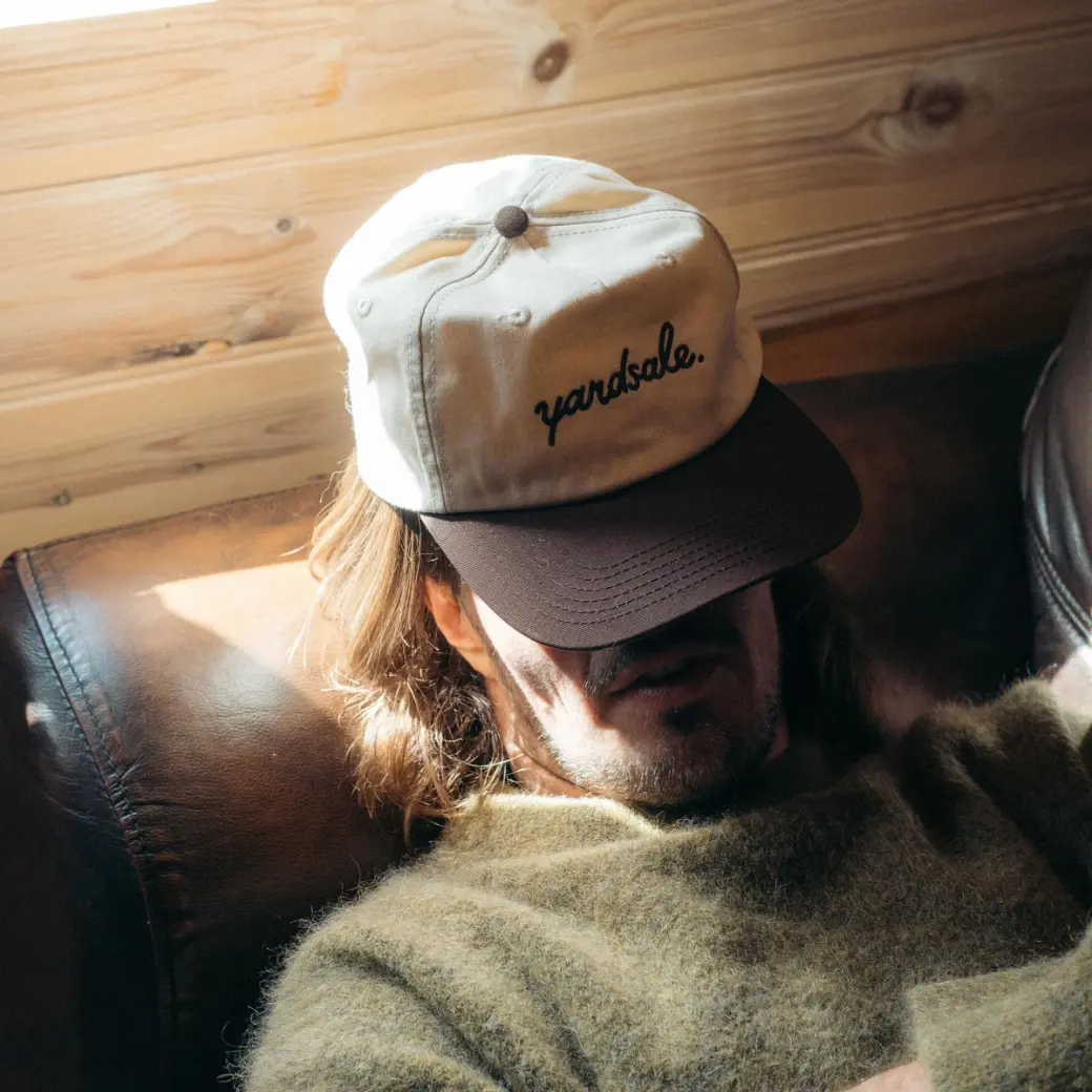 An image of a man with a hat covering his face
